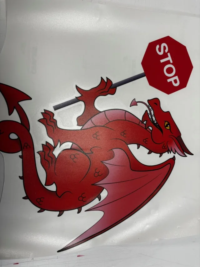 Custom printed sticker featuring a red Welsh dragon holding a stop sign
